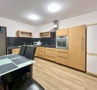 2-izbový byt 80m2 | Bratislavská - Svätý Jur - Kuchyňa s podlahou s dreveným dekorom v 2-izbovom byte so spotrebičmi a jedálenským stolom.