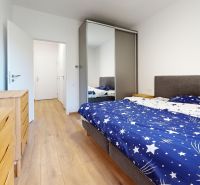 PRENÁJOM 2 izbový, zariadený byt v Danube residencia - REZERVOVANÉ - Spálňa s posteľou, vstavanou skriňou a podlahou s dreveným dekorom v 2-izbovom byte.