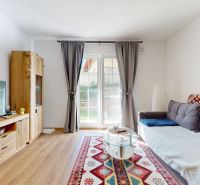 PRENÁJOM 2 izbový, zariadený byt v Danube residencia - REZERVOVANÉ - Obývačka 2-izbového bytu s pohovkou, televízorom a podlahou s dreveným dekorom.