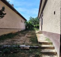 Predám 3 izbový dom v Tvrdošovciach - Rodinný dom na Tvrdošovciach s dvorom, kde vedú schody medzi dvoma budovami.