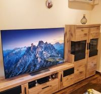 Svetlý a tichý 3i byt po rekonštrukcii, s panoramatickým výhľadom - Obývacia miestnosť s televízorom, dekoratívnym nábytkom a podlahou s dreveným dekorom v 3-izbovom byte.