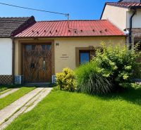 Na predaj starší rodinný dom v obci Budmerice 541m2 - Rodinný dom na Juraja Holčeka v Budmericiach s červenou strechou a zeleným trávnikom.