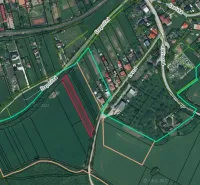 Podhájska - 2.084 m2 POZEMOK na okraji obce - Letecký pohľad na poľnohospodárske a lesné pozemky v Podhájskej s viditeľnou cestnou sieťou.