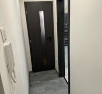 Ponúkame moderne zariadený byt na Zelenečskej  - Chodba v 2-izbovom byte s tmavými dverami a stenovým interkomom.