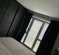Ponúkame moderne zariadený byt na Zelenečskej  - Spálňa v 2-izbovom byte s posteľou a oknom, preverená realitná kancelária.