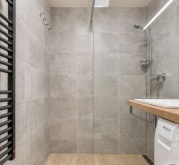 2-izbový byt s PARKOVACÍM MIESTOM lokalita CHOPOK JUH - Moderná kúpeľňa so sprchovacím kútom a podlahou s dreveným dekorom v 2-izbovom byte.