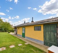 Predaj 4i dom, 52 m2 garáž, 518 m2 pozemok, Mosonmagyaróvár - Záhrada rodinného domu v Mosonmagyaróvári s trávnikom a stromami.