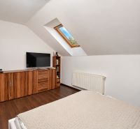 Predaj 4i dom, 52 m2 garáž, 518 m2 pozemok, Mosonmagyaróvár - Podkrovná spálňa s podlahou s dreveným dekorom v rodinnom dome.
