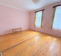 Predaj 3i rodinný dom, 900 m2 pozemok, Dunakiliti - Miestnosť rodinného domu s podlahou s dreveným dekorom, stolíkom a záclonami.