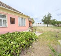 Predaj 3i rodinný dom, 900 m2 pozemok, Dunakiliti - Rodinný dom v Dunakiliti s ružovou fasádou a záhradou plnou zelene.