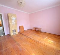 Predaj 3i rodinný dom, 900 m2 pozemok, Dunakiliti - Izba v rodinnom dome s kachľovou pecou a podlahou s dreveným dekorom.