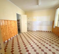 Predaj 3i rodinný dom, 900 m2 pozemok, Dunakiliti - Kuchyňa v rodinnom dome s dlažbou a dreveným obkladom na stenách.