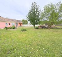 Predaj 3i rodinný dom, 900 m2 pozemok, Dunakiliti - Rodinný dom v Dunakiliti s ružovou fasádou obklopený priestrannou záhradou a stromami.
