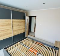 Na predaj 3 i byt 73 m2 s loggiou Partizánske – balkón, komora, špajza - Spálňa so vstavanou skriňou a posteľou v 3-izbovom byte s podlahou s dreveným dekorom.