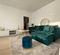 Prenájom krásny útulný 3 izbový byt Kafendova ul. Bratislava III Rača - Obývacia izba v 3-izbovom byte s tmavozelenou sedačkou a stolíkom na svetlom koberci.