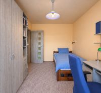 3-IZBOVÝ BYT S KLIMATIZÁCIOU – HAVANSKÁ - SÍDLISKO ŤAHANOVCE, KOŠICE - Izba v 3-izbovom byte s posteľou, skriňou, stolom a modrým kreslom.