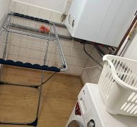 Útulné a kompletne zariadené bývanie v rodinnom dome so záhradkou – Pi - Práčovňa v rodinnom dome s práčkou, sušiakom a podlahou s dreveným dekorom.