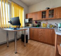 REZERVOVANÉ Na predaj 1 izbový byt Martin – Podháj, ulica Timravy - Kuchyňa v 1-izbovom byte s podlahou s dreveným dekorom a žltými závesmi.