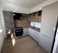 2-izb. byt, Galbavého, Dúbravka, kompletná rekonštrukcia  - Kuchyňa v 2-izbovom byte so zabudovanými spotrebičmi a podlahou s dreveným dekorom.