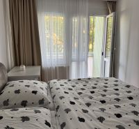 PRENÁJOM 3 izbový byt s parkovaním na Hroncovej ulici, Košice - Sever - Spálňa v 3-izbovom byte s posteľou a závesmi, otvorené balkónové dvere.