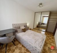 Priestranný 3i byt s balkónom a garážou v Petržalke - Spálňa v 3-izbovom byte s posteľou, šatníkovou skriňou a podlahou s dreveným dekorom.