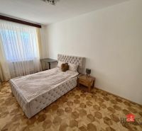 Priestranný 3i byt s balkónom a garážou v Petržalke - Spálňa s posteľou, nočným stolíkom a podlahou s dreveným dekorom, 3-izbový byt.