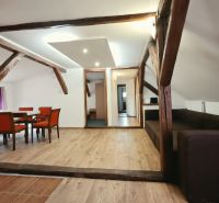Na predaj zabehnutý Apartmánový dom v Podhájskej s parkovaním - Rekreačný apartmán s podlahou s dreveným dekorom, drevenými trámami a pohodlným nábytkom.