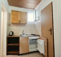 Na predaj zabehnutý Apartmánový dom v Podhájskej s parkovaním - Kuchynský kút v Rekreačnom apartmáne s drevenými skrinkami, drezom a minichladničkou.