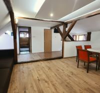 Na predaj zabehnutý Apartmánový dom v Podhájskej s parkovaním - Rekreačný apartmán s drevenými trámami a podlahou s dreveným dekorom ponúka jedálenský kút.
