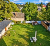Zrekonštruovaný rodinný dom 215 m² na pozemku 1 530 m² | Martin - Záhrada rodinného domu v Martine s trávnikom a viditeľnými strechami neďalekých budov.