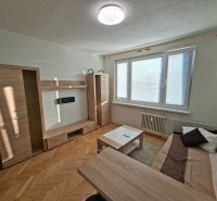 DOBRÉ REALITY-pekná garsónka na prenájom, sídl. Kopanice, Prievidza - Garsónka so svetlým nábytkom, pohovkou a podlahou s dreveným dekorom.