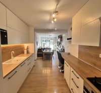 Predaj 3 izbový byt s balkónom - Humenné, Ševčenkova - Kuchyňa v 3-izbovom byte s podlahou s dreveným dekorom a bielymi skrinkami.