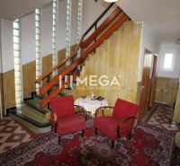 Rezervované - na predaj dom na vynikajúcom pozemku priamo v meste Hume - Vnútri rodinného domu sú schody, dve červené kreslá a koberec s geometrickým vzorom.