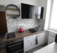Na prenájom plne zariadená garsónka blízko centra - Humenné - Kuchyňa Rekreačného apartmánu s čiernymi skrinkami, varnou doskou a dekoratívnym obkladom.