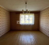 Na PREDAJ - Dom s krásnym pozemkom v Zbudskej Belej - Izba s tapetami a podlahou s dreveným dekorom v rodinnom dome.