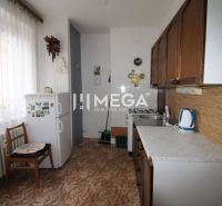 NA PREDAJ - 2 iz. byt s balkónom blízko centra mesta Humenné - Kuchyňa v 2-izbovom byte s chladničkou, podlaha s dreveným dekorom, svetlá záclona.