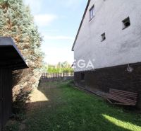 NA PREDAJ - Dom v obci Volica - Záhrada pri rodinnom dome na ulici Volica v meste Volica s lavičkou a ihličnanmi.