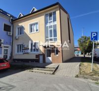 PRENÁJOM OBCHODNÉHO PRIESTORU PRIAMO V CENTRE HUMENNÉHO - Budova s obchodnými priestormi na Námestí Slobody v Humennom, pred ktorou sú parkovacie miesta.