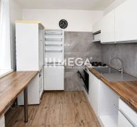 Na predaj - Priestranný 3-izb byt po rekonštrukcii v Snine - Kuchyňa v 3-izbovom byte s podlahou s dreveným dekorom a elegantnou kuchynskou linkou.