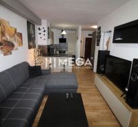 REZERVOVANÝ - Na predaj moderný 2-izbový byt po rekonštrukcii - Obývačka v 2-izbovom byte s rohovou sedačkou a podlahou s dreveným dekorom.