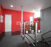 NA PRENÁJOM: 2x Moderná, klimatizovaná kancelária s parkovaním a optic - Kancelárie s červenou stenou a šedými podlahami, rastliny a kovové zábradlie.