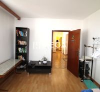 DOHODA NA CENE NA PREDAJ 4-IZBOVÝ BYT 88 m² S LOGGIOU HUMENNÉ - Izba v 4-izbovom byte s policou na knihy a podlahou s dreveným dekorom.