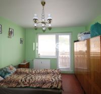 DOHODA NA CENE NA PREDAJ 4-IZBOVÝ BYT 88 m² S LOGGIOU HUMENNÉ - Spálňa v 4-izbovom byte s posteľou, skriňou a zelenými stenami.