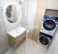 NA PRENÁJOM PRÉMIOVÝ 3-IZBOVÝ BYT – CENTRAL POINT HUMENNÉ - Kúpeľňa v 3-izbovom byte s pračkou, sušičkou a osvetleným okrúhlym zrkadlom.