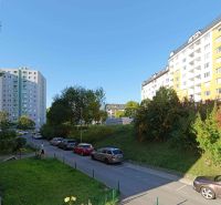 Praktický 3i BYT s obľúbenou dispozíciou - Rozkvet - PB - Ulica Rozkvet, Považská Bystrica, s bytovými domami a zaparkovanými autami pri 3-izbovom byte.