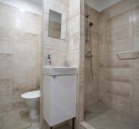 REZERVOVANÉ 1 izbový byt s balkónom - až 41m² N. DUBNICA - Kúpeľňa v 1-izbovom byte s umývadlom, sprchou a béžovým obkladom.