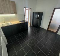 PRENÁJOM Bánovce nad Bebravou/2 IZBOVÝ BYT/CENTRUM-STRED/70m2 - Kuchyňa v 2-izbovom byte s čiernymi skrinkami a podlahou s textúrou.