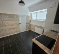 PRENÁJOM Bánovce nad Bebravou/2 IZBOVÝ BYT/CENTRUM-STRED/70m2 - Kuchyňa v 2-izbovom byte s obkladom z tehál a čiernou dlažbou.