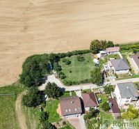 8,5 árov pokoja a krásnych výhľadov na okraji intravilánu - Letecký pohľad na záhrady v Pastuchove, obklopené domami a poľami.