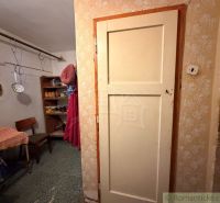 Dom v tichej uličke pri Hurbanove – miesto pre váš vidiecky sen - Interiér rodinného domu s predsieňou, stoličkou a regálmi. Visia tu kuchynské nástroje.